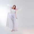 Young, wonderful blonde girl in the image of an angel with white wings. Royalty Free Stock Photo