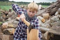 Young Woodcutter Splitting Piece of Firewood with An Axe Royalty Free Stock Photo