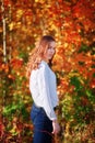 Young wooman. Dreamy pretty girl in bright autumn orange leaves