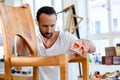 Young worker in a carpenters workshop with wooden chair Royalty Free Stock Photo
