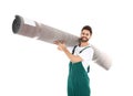 Young worker carrying rolled carpet  on white. Moving service Royalty Free Stock Photo