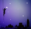Young worker decorating the city sky with stars or lanterns, silhouette, fairy tale above the night city, night