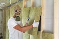 Young worker in gas mask insulating rock wool insulation staff i Royalty Free Stock Photo