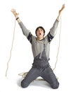 A young worker in grey uniform tied up with rope on white isolated background. Royalty Free Stock Photo