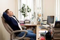 Young worker having break and resting after solving task Royalty Free Stock Photo