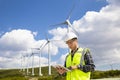 Young worker looking and checking wind turbines at field Royalty Free Stock Photo