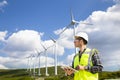 Young worker looking and checking wind turbines at field Royalty Free Stock Photo