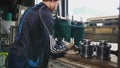 Young worker puts compressor metal details into workbody