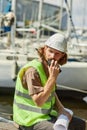 Young worker speaking to radio in yacht docks