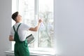 Young worker tinting window with foil. Space for text