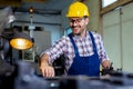 Worker in uniform operating in manual lathe in metal industry factory. Royalty Free Stock Photo