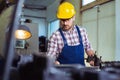 Worker in uniform operating in manual lathe in metal industry factory. Royalty Free Stock Photo