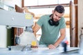 Young worker in a carpenters workshop using saw Royalty Free Stock Photo
