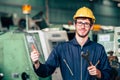 Young worker with wrench repair engineer fix machine happy smiling in factory hand thumb up for good job signal Royalty Free Stock Photo