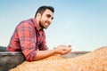 Young male worker, young farmer on farmland smiling and holding corn at sunset Royalty Free Stock Photo