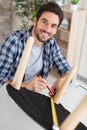 Young working man repairing chair at home