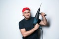 Young working man with rotary hammer on light Royalty Free Stock Photo