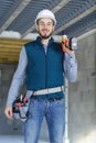 young workman wearing toolbelt and holding drill Royalty Free Stock Photo