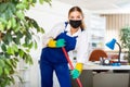 Workwoman of cleaning service in protective mask mopping floors in office Royalty Free Stock Photo