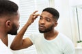 Young worried african man checking his wrinkles Royalty Free Stock Photo