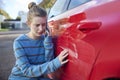 Young Worried Teenage Female Driver With Damaged Car After Accident Calling Insurance Company On Mobile Phone Royalty Free Stock Photo