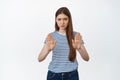 Young worried woman showing stop gesture, raising palms to show prohibiton sign, warning, say no, rejecting smth Royalty Free Stock Photo