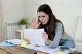 Young worried woman suffering stress doing domestic accounting paperwork bills