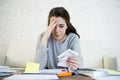 Young worried woman suffering stress doing domestic accounting paperwork bills