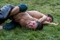 A young wrestler is overpowered by his opponent at the Elmali Turkish Oil Wrestling Festival in Turkey. Royalty Free Stock Photo