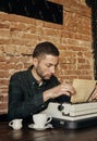 Young writer prints his texts on an old typewriter. He just typed something. Royalty Free Stock Photo