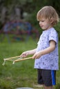 Young, 4 year old preschool boy with a grey shirt and blond hair, blowing bubbles in the yard Royalty Free Stock Photo