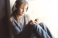 Young 10 years woman listening music close to the window