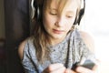 Young 10 years woman listening music close to the window