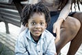 Young 5 yo boy smiling at the camera. Portrait close up of little guy enjoying time outdor with his mommy. Family with black Royalty Free Stock Photo