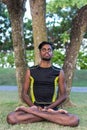 Young yoga man practitioners doing yoga on nature. Asian indian yogis man on the grass in the park. Bali island. Royalty Free Stock Photo