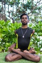 Young yoga man practitioners doing yoga on nature. Asian indian yogis man on the grass in the park. Bali island. Royalty Free Stock Photo