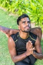 Young yoga man practitioners doing yoga on nature. Asian indian yogis man on the grass in the park. Bali island. Royalty Free Stock Photo