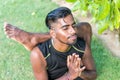 Young yoga man practitioners doing yoga on nature. Asian indian yogis man on the grass in the park. Bali island. Royalty Free Stock Photo