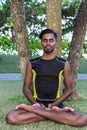 Young yoga man practitioners doing yoga on nature. Asian indian yogis man on the grass in the park. Bali island. Royalty Free Stock Photo