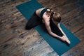 Young yoga woman practicing on blue mat indoors Royalty Free Stock Photo