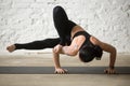 Young yogi attractive woman in Maksikanagasana pose, white loft