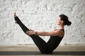 Young yogi attractive woman in Paripurna Navasana pose, white ba Royalty Free Stock Photo