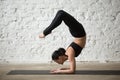 Young yogi attractive woman in vrischikasana pose, white loft ba Royalty Free Stock Photo