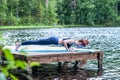 yogi girl practicing yoga, doing four limbed staff, chaturanga dandasana pose, on the lake. Concept of healthy life and