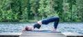 Young yogi girl practicing yoga, Glute Bridge exercise, dvi pada pithasana pose on the lake. Concept of healthy life and