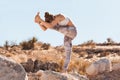 Young yogi woman practicing yoga in desert before a sunset