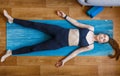 Young yogi woman relaxing in shavasana pose home