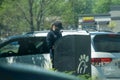 Young youthful fast food worker working at Chick-fil-a drive through amidst cars take orders with tablet