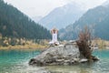 Young zen man in meditation. Outdoor yoga in mountain lake. Exercise Agni Stambhasana