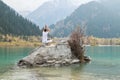 Young zen man in meditation. Outdoor yoga in mountain lake. Exercise Agni Stambhasana